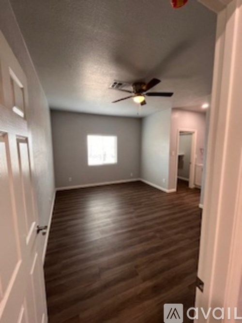 A room with wooden floors and a ceiling fan.