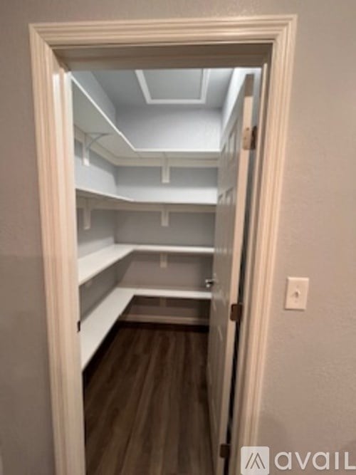 A white door opens to a small room with a skylight.