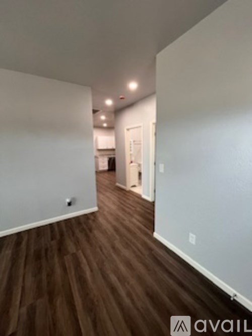 A room with wooden flooring and white walls.