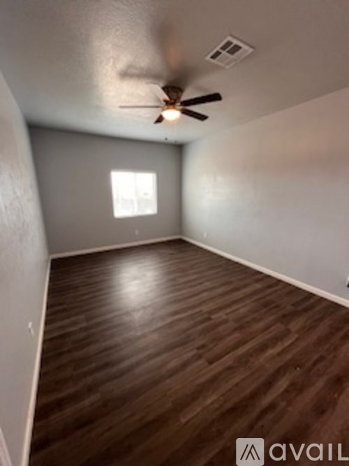 A room with wooden flooring and a ceiling fan.
