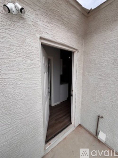 A small white doorway leads to a dark room.