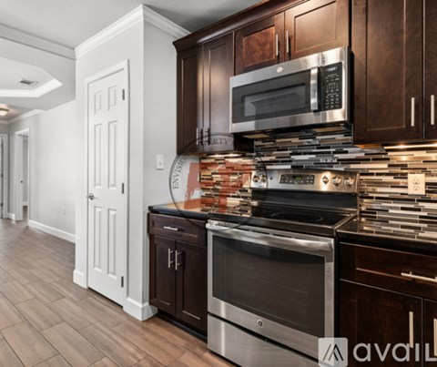 A kitchen with dark wood cabinets and stainless steel appliances.