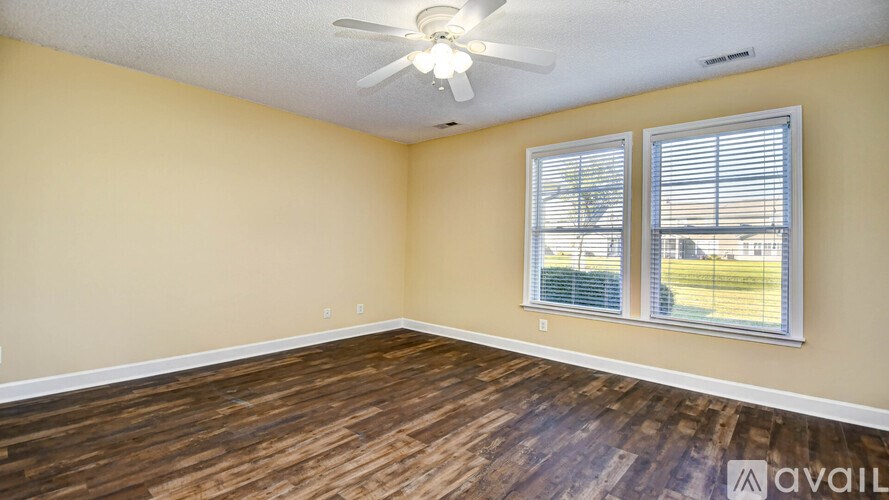 A room with wooden flooring and a ceiling fan.