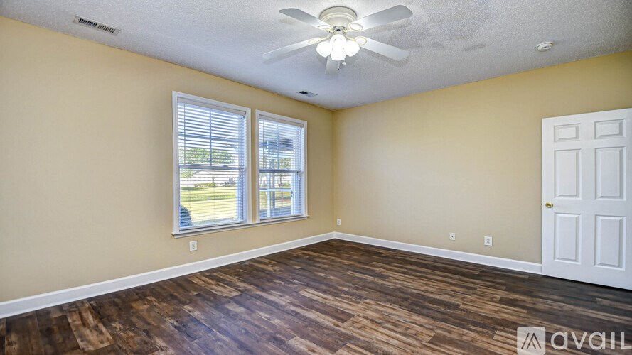 A room with a ceiling fan and a door.