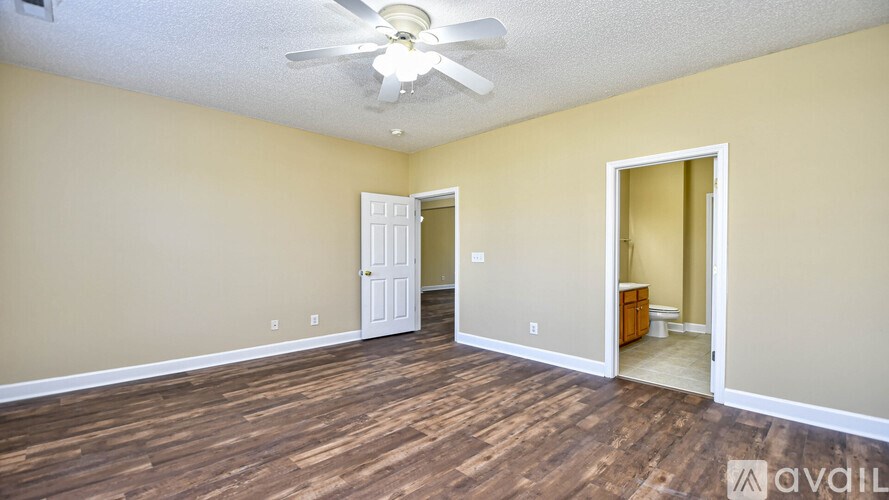 A room with a ceiling fan and wooden flooring.