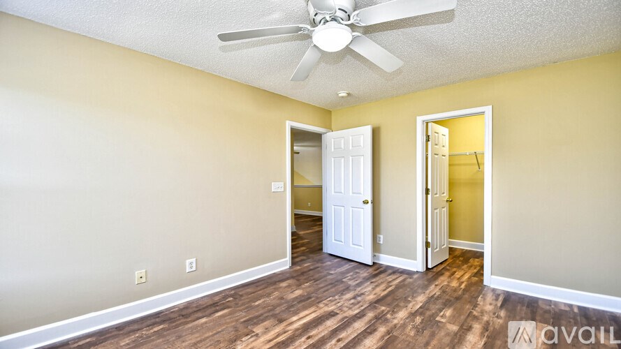 A room with a ceiling fan and two doors.