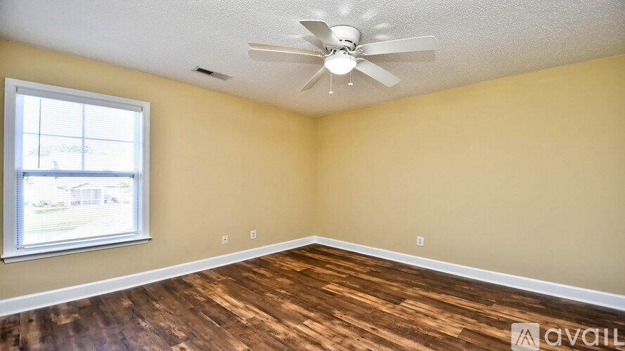 A room with a ceiling fan and a window.