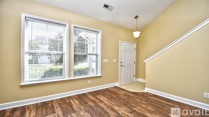 A room with a white door and a window with blinds.