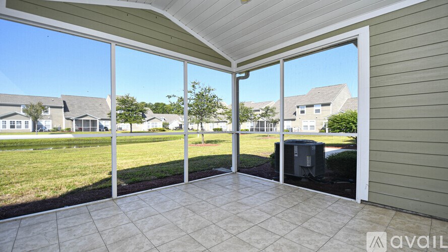 A patio with a tiled floor and sliding glass doors leading to a grassy area.