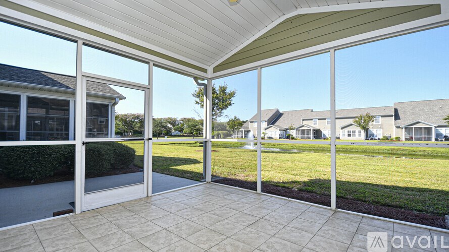 A sunroom with a tiled floor and sliding glass doors.