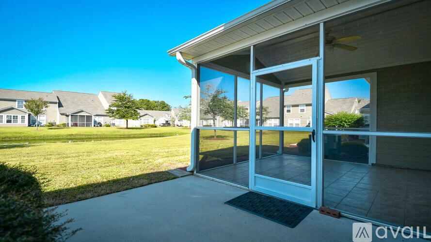 A sunny day at a residential area with a house and a covered patio.
