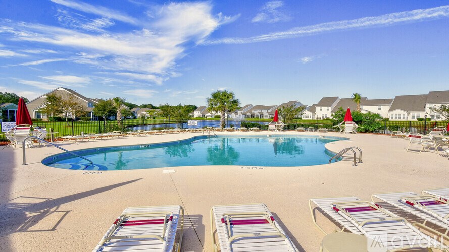 A large swimming pool surrounded by sun loungers and umbrellas.