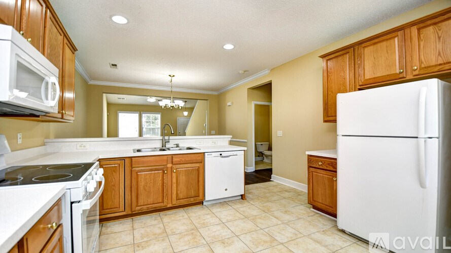 A kitchen with white appliances and wooden cabinets.