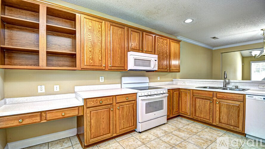 A kitchen with wooden cabinets and white appliances.