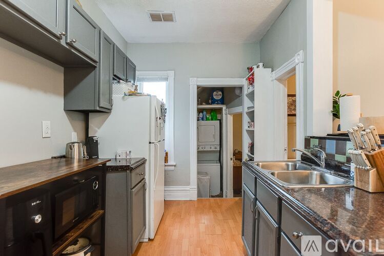 A kitchen with a refrigerator, microwave, and oven.