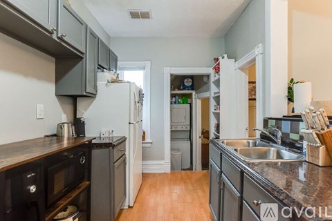 A kitchen with a refrigerator, microwave, and oven.
