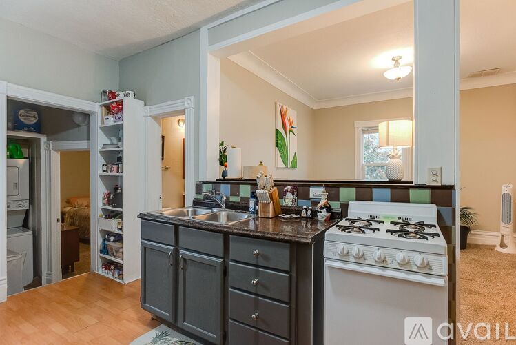 A kitchen with a white stove top oven and a dark grey cabinetry.