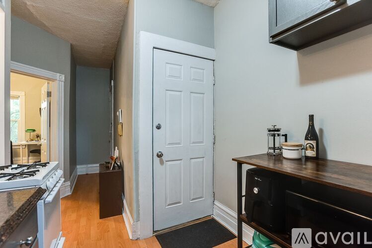A kitchen with a white door and a black counter top.