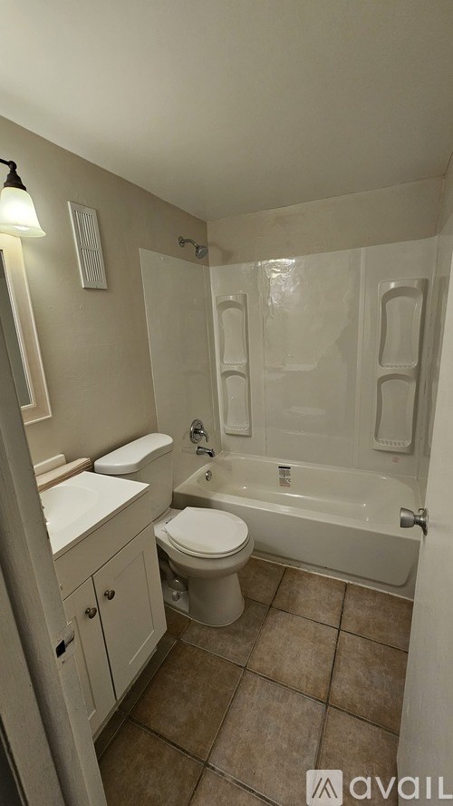 A bathroom with a toilet, sink, and bathtub.