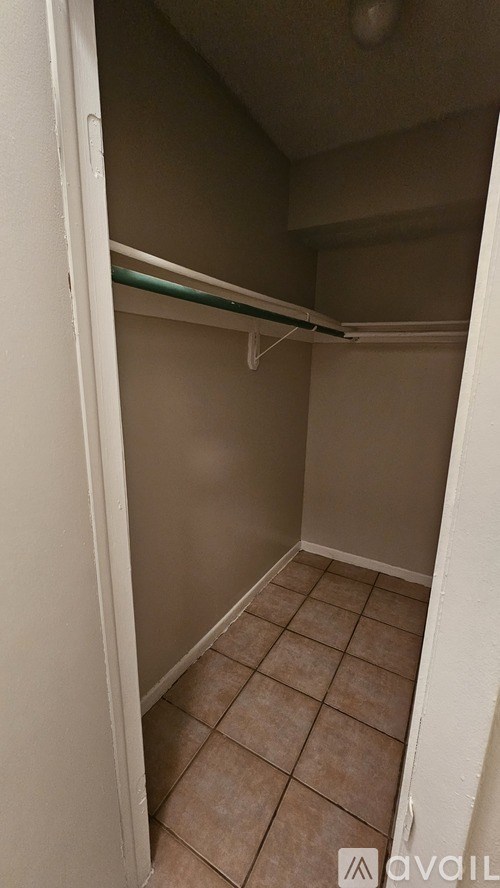 A small, empty room with a tiled floor and a single shelf.