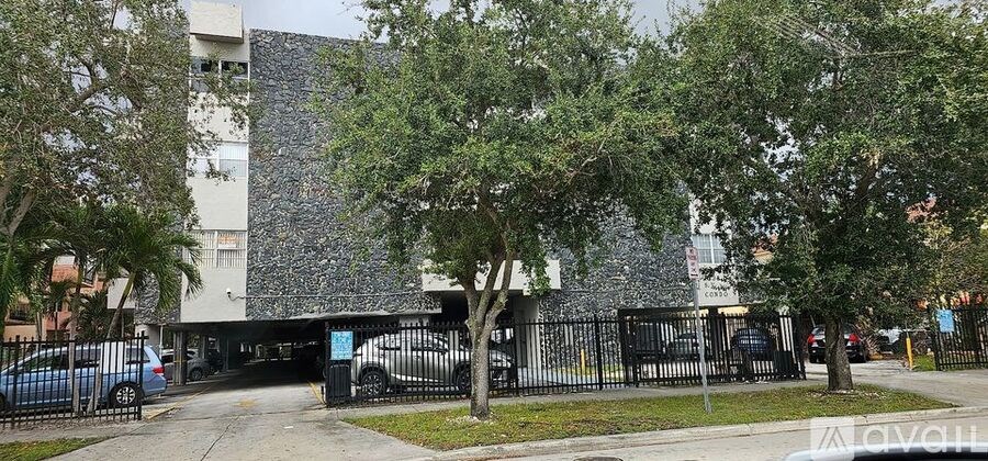 A building with a grey facade and a black gate in front.