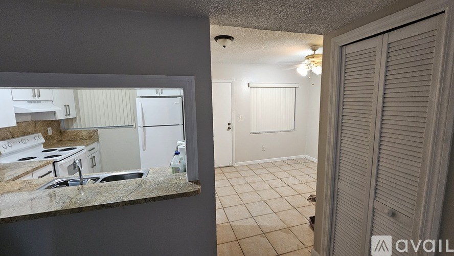 A kitchen with a stove and a refrigerator is shown in the reflection of a mirror.