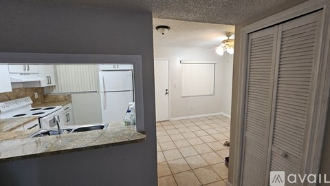 A kitchen with a stove and a refrigerator is shown in the reflection of a mirror.