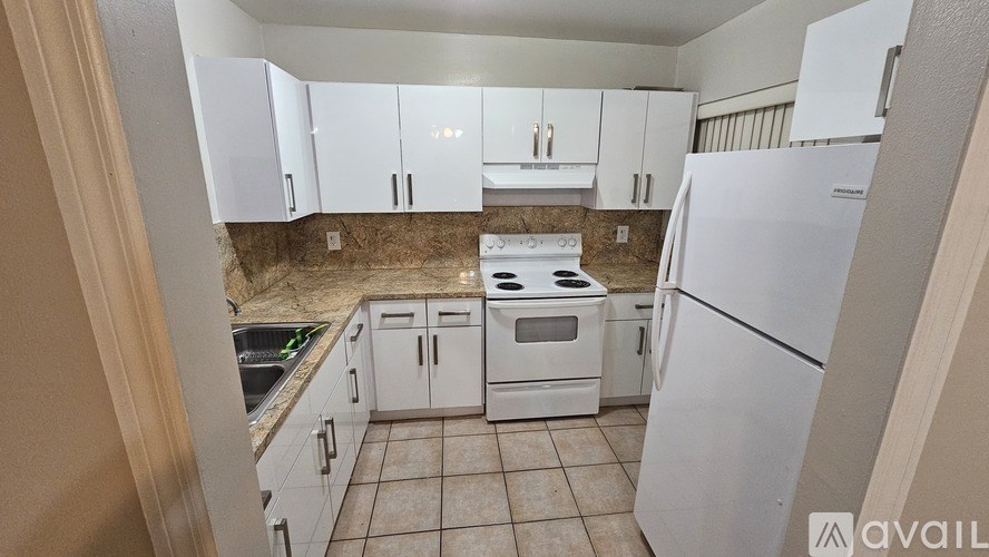 A kitchen with white appliances and cabinets.