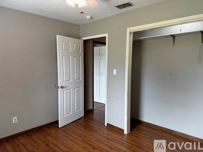 A room with a white door and a wooden floor.