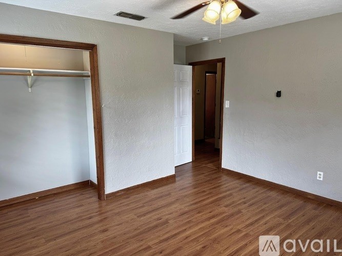 A room with wooden floors and a ceiling fan.