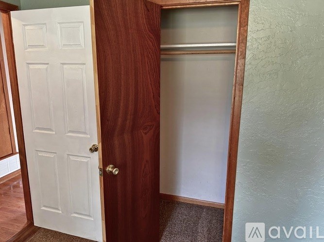 A white door is open to a room with a brown door.