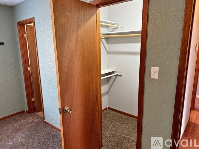 A room with a wooden door and a carpeted floor.