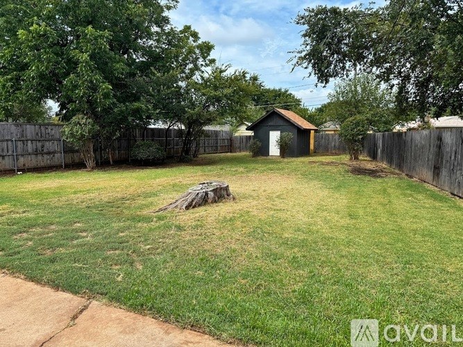 A backyard with a fence and a small shed.