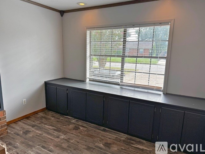 A room with a window and a wall with a shelf.