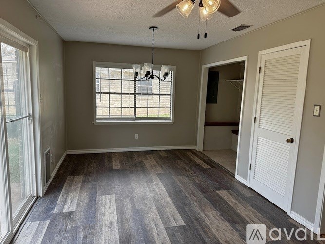 A room with a ceiling fan and a window with blinds.
