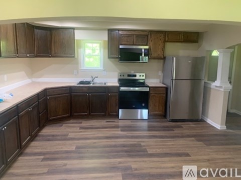 A kitchen with wooden cabinets and a stainless steel refrigerator.