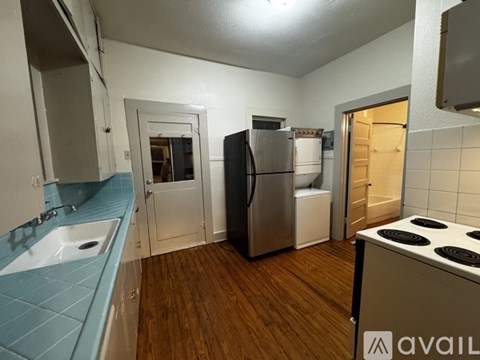 A kitchen with wooden floors and white cabinets.