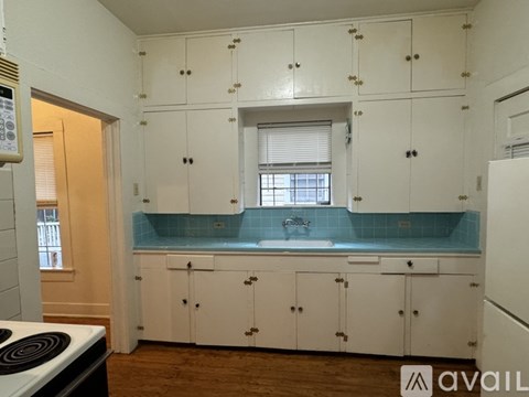 A kitchen with white cabinets and a blue counter.