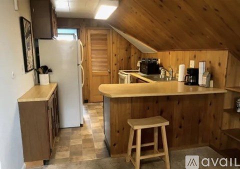A kitchen with wooden cabinets and a white refrigerator.