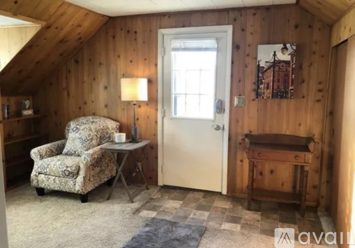 A room with wooden walls and a chair.