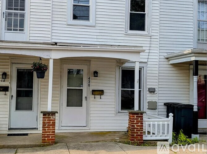 A white house with a grey door and windows.