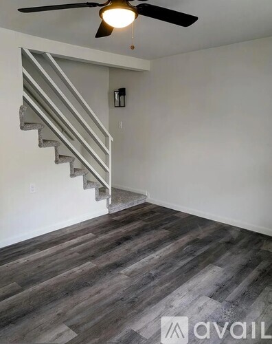 A room with a staircase and a ceiling fan.