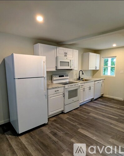 A kitchen with white appliances and cabinets.