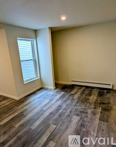 A room with wooden flooring and a window.