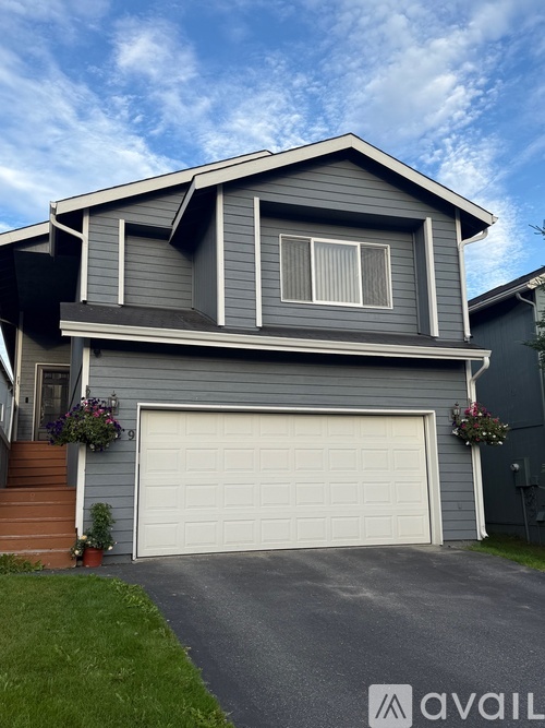 A two-story house with a garage and a driveway.