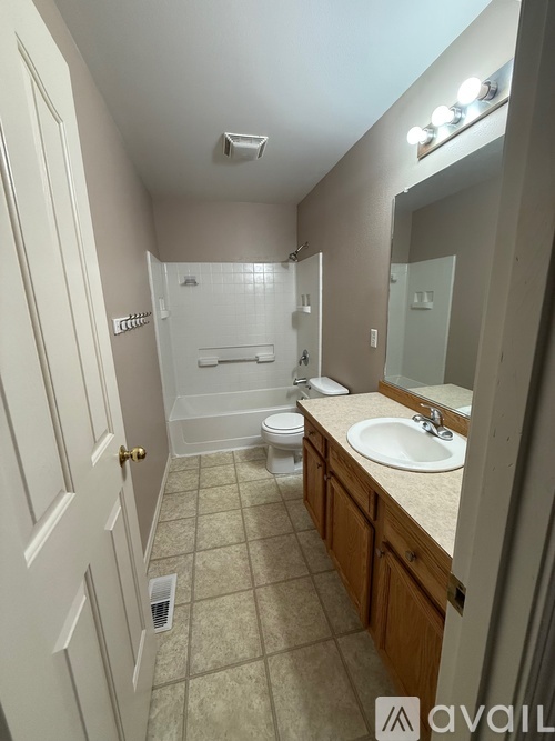 A bathroom with a toilet, sink, and mirror.