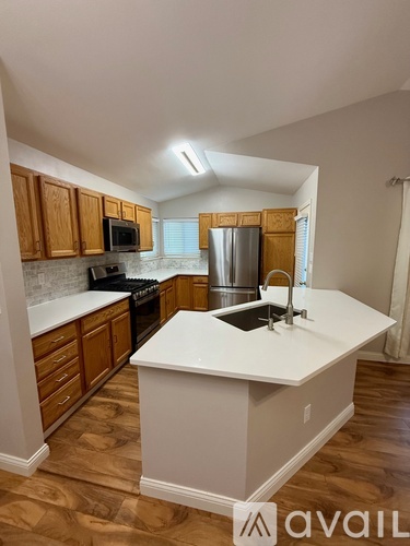 A kitchen with wooden cabinets and a white island.