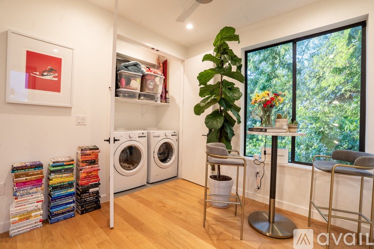A room with a pile of books and two washing machines.