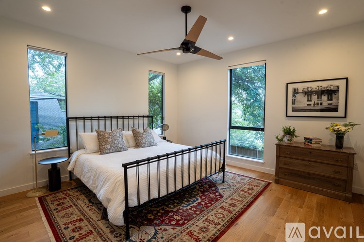 A bedroom with a large bed and a ceiling fan.