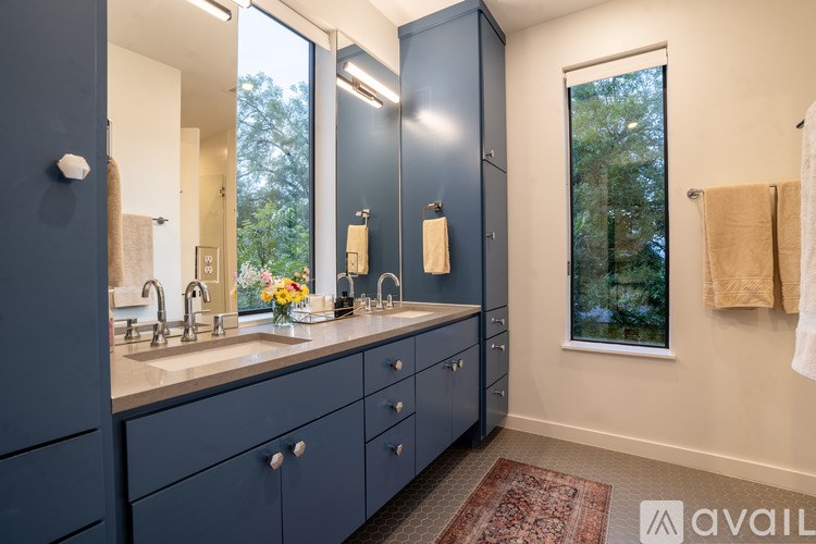 A bathroom with a sink, mirror, and a window.